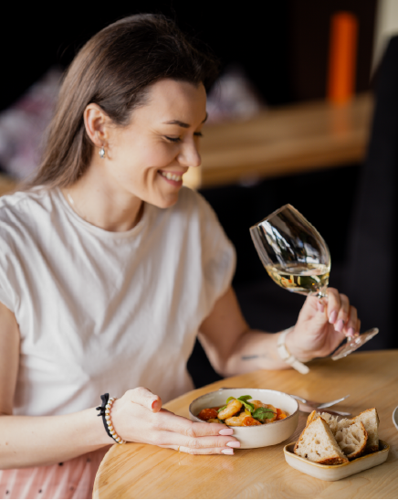 Gość restauracji Feeria przy stole z kieliszkiem wina